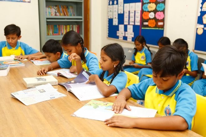 Royal Concorde students reading and writing at their desks during a lesson