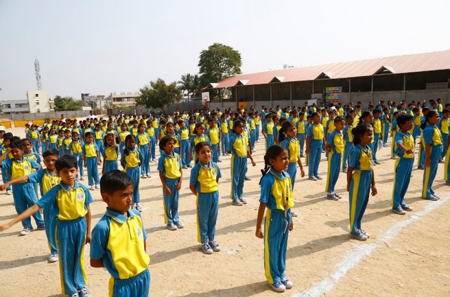 Students lined up in formation on the ground for a whole-school assembly