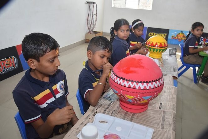 Students painting patterned pots during an arts and craft session