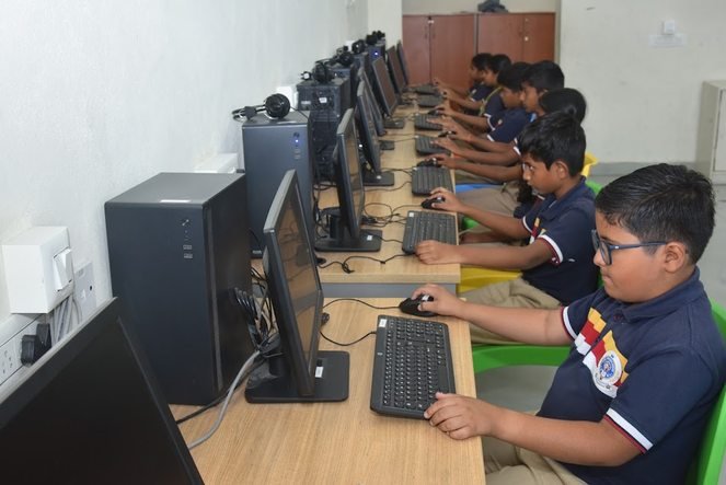 Students at work along a row of desktop computers in the computer laboratory